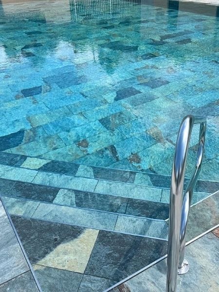 Détail du bassin de la piscine du Aloha Camping Club avec escaliers immergés et eau turquoise